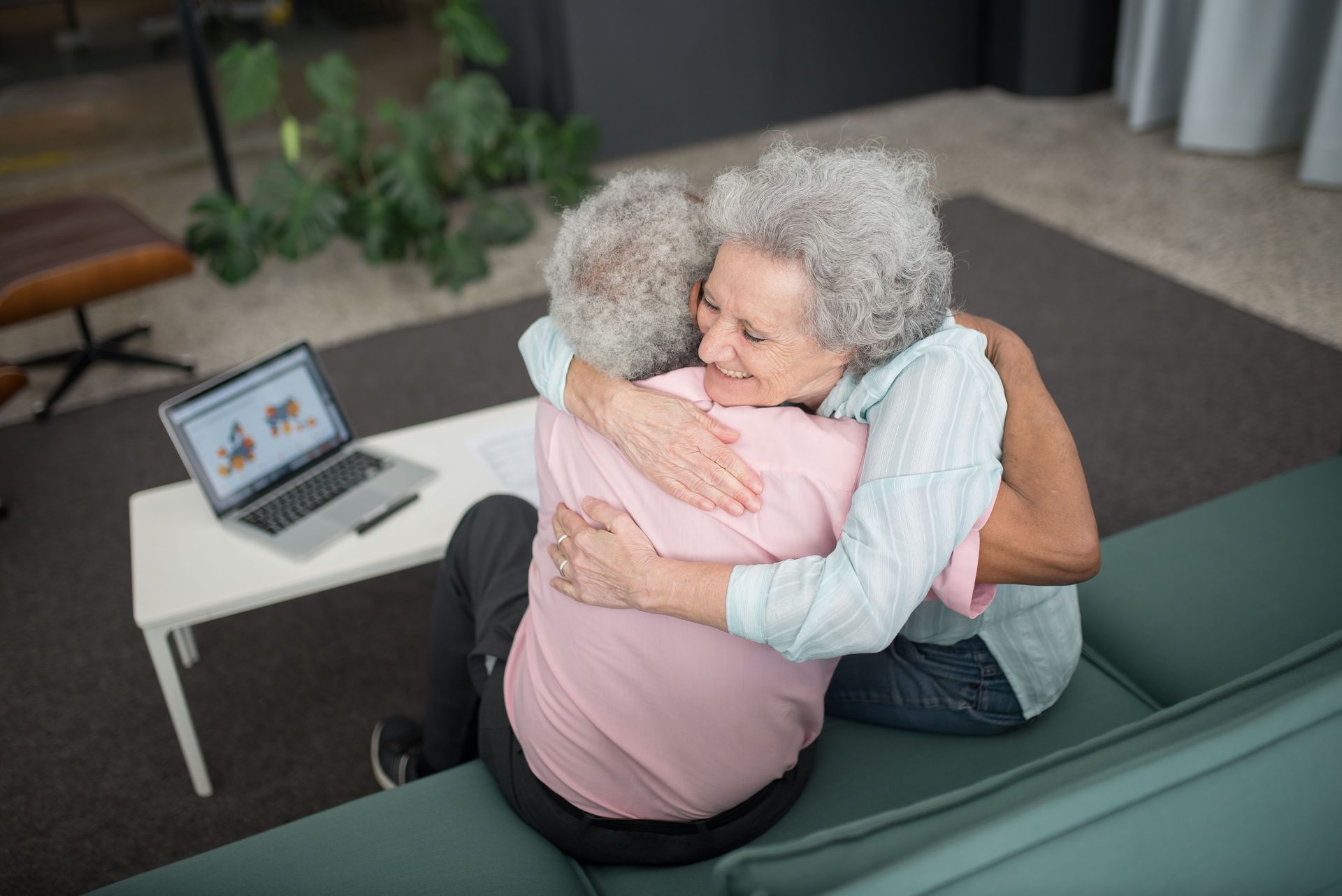 A joyful moment of a senior couple embracing indoors, highlighting warmth and companionship.